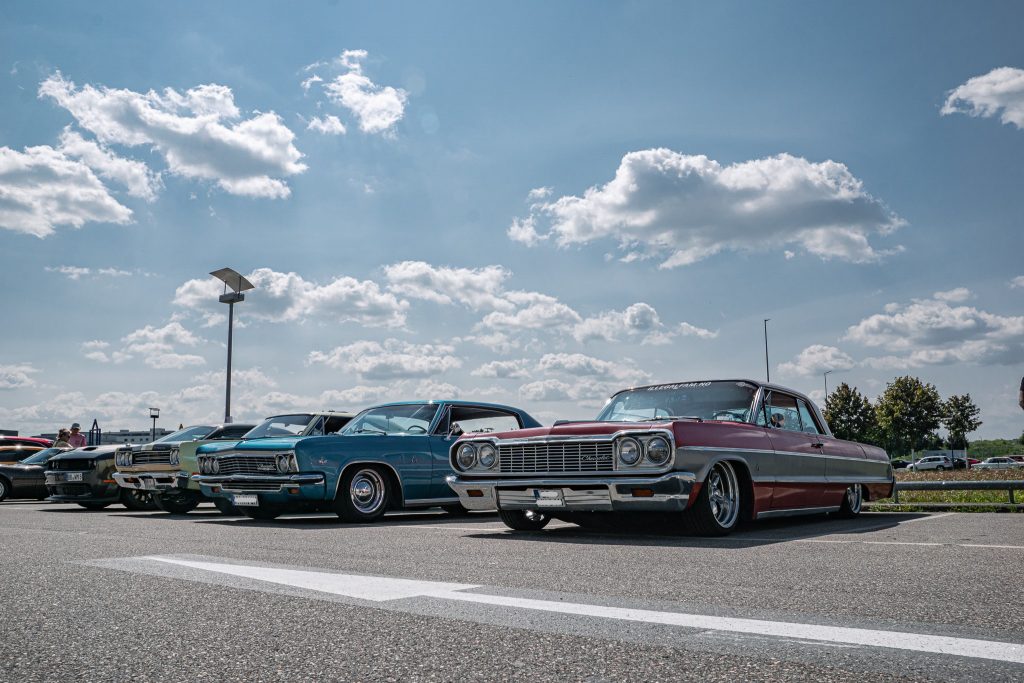 Klassische amerikanische Autos in einer Reihe geparkt auf einem Sonnentag an einer Eventlocation im Freien