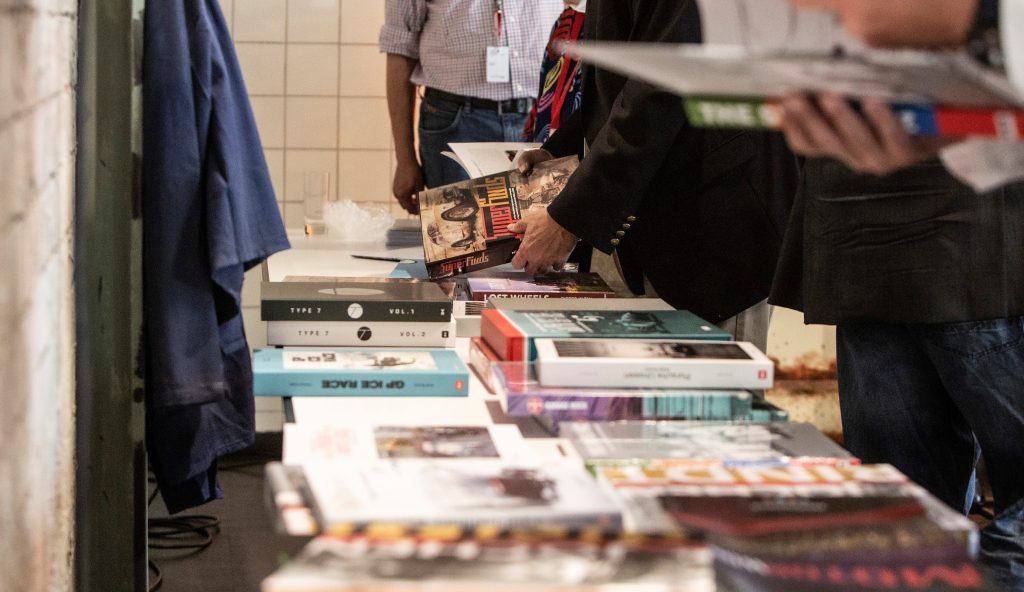 Menschen betrachten Bücher auf einem Tisch bei einem Event in einer Eventlocation