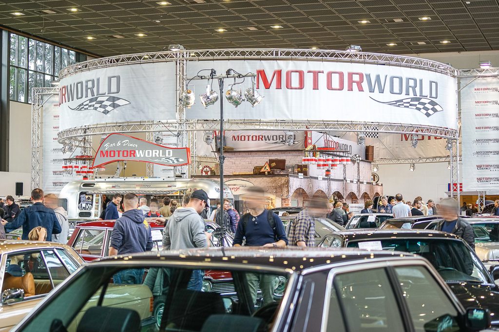 Belebtes Event mit Oldtimern in der Eventlocation MOTORWORLD mit zahlreichen Besuchern und Ausstellungshalle