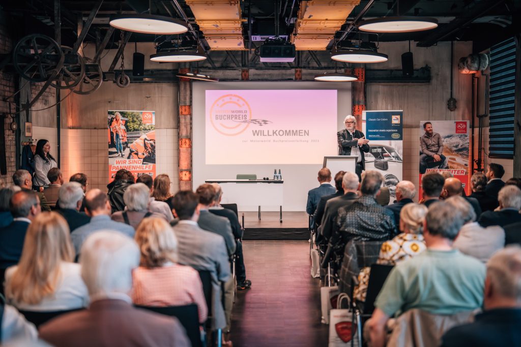 Vortrag auf Event mit Publikum in moderner Eventlocation bei Motorworld Buchpreisverleihung 2023