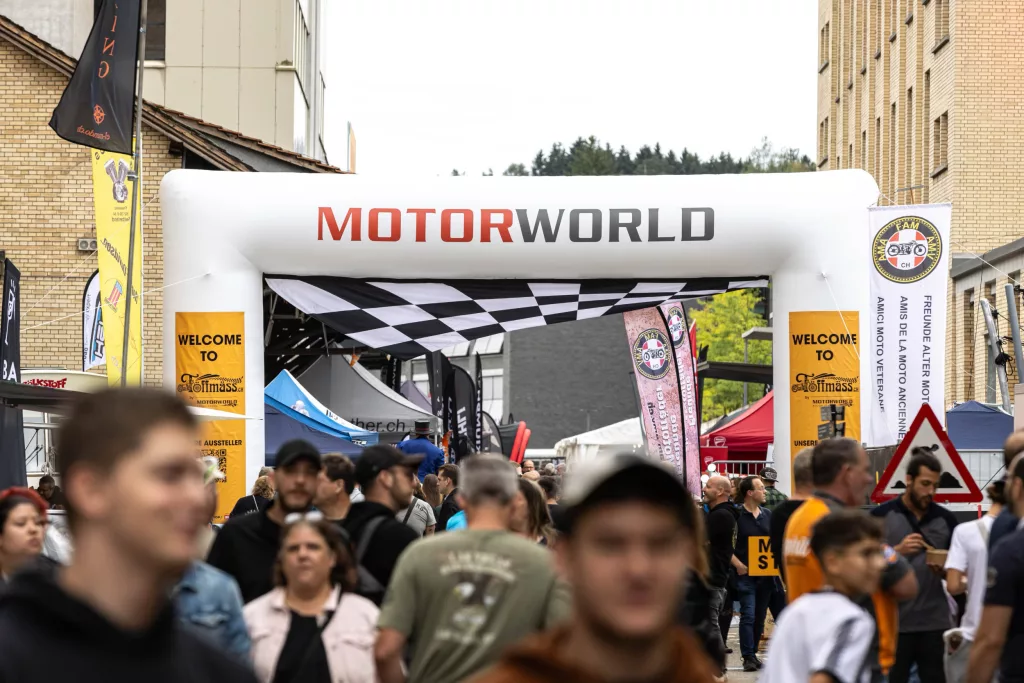 Menschenmenge bei einem Motor-Event unter einem aufblasbaren Tor mit der Aufschrift MOTORWORLD in der Eventlocation