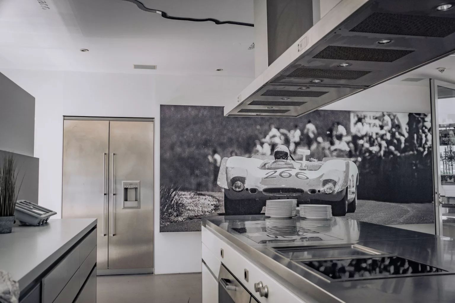 Modern kitchen with stainless steel appliances and mural of historic racing car, elegant and bright event location