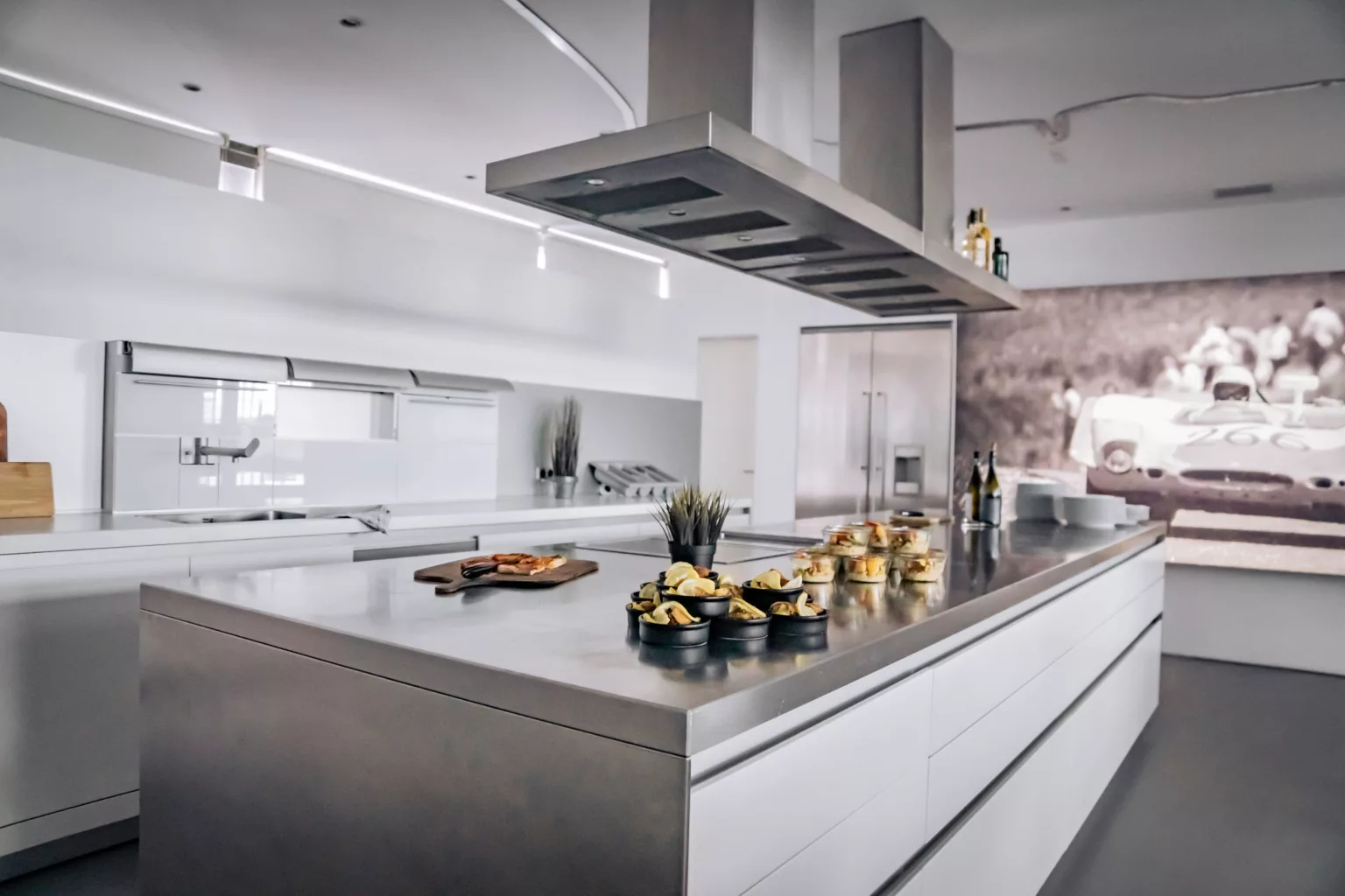 Modern event location with large stainless steel kitchen island and stylishly prepared snacks for events