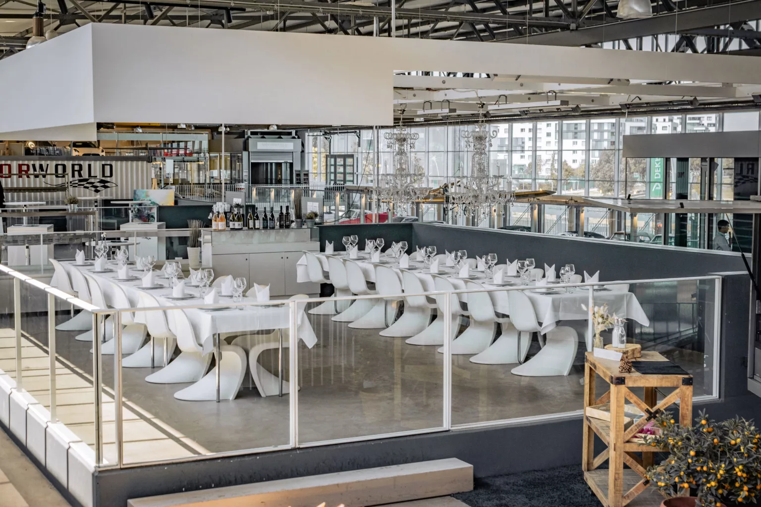 Modern event location with elegantly laid tables and white chairs in an open space with large windows