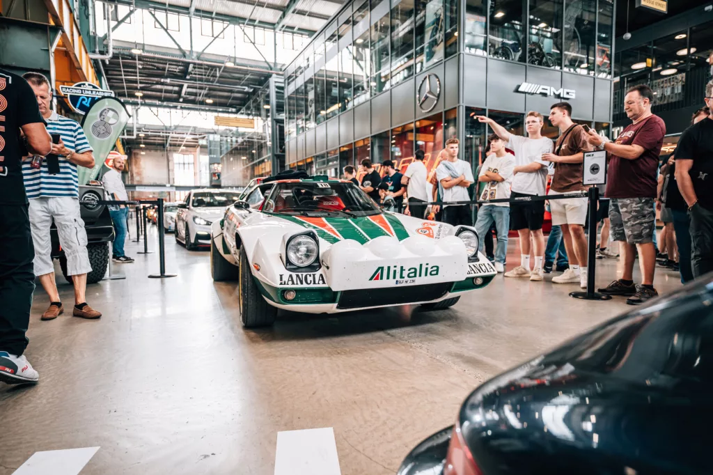 Event mit Rallye-Klassiker Lancia Stratos in Eventlocation mit Mercedes-AMG Showroom und Besuchern