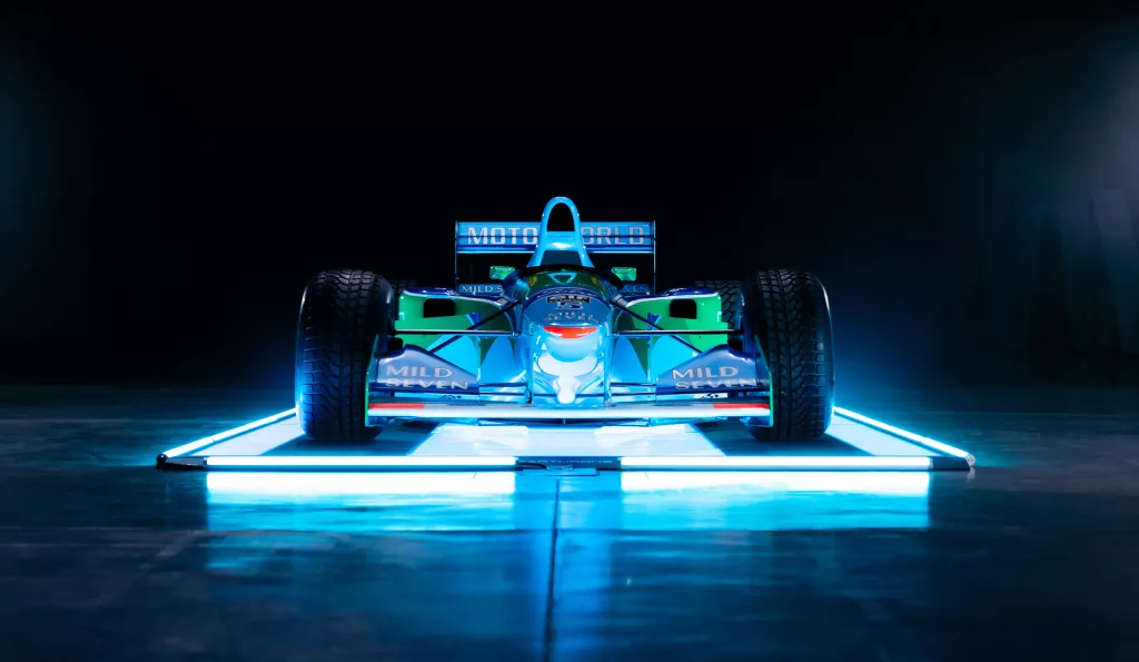 Historisches Formel-1-Rennwagen-Modell in beleuchteter Eventlocation vor dunklem Hintergrund