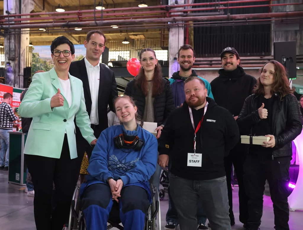 Fröhliche Gruppe von Menschen bei einem Event in einer Industrie-Eventlocation mit freundlicher Atmosphäre