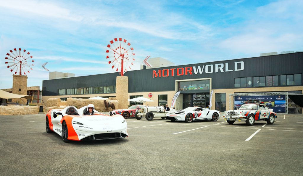 Motorsport-Event mit historischen und modernen Rennwagen vor der Eventlocation MOTORWORLD an einem sonnigen Tag
