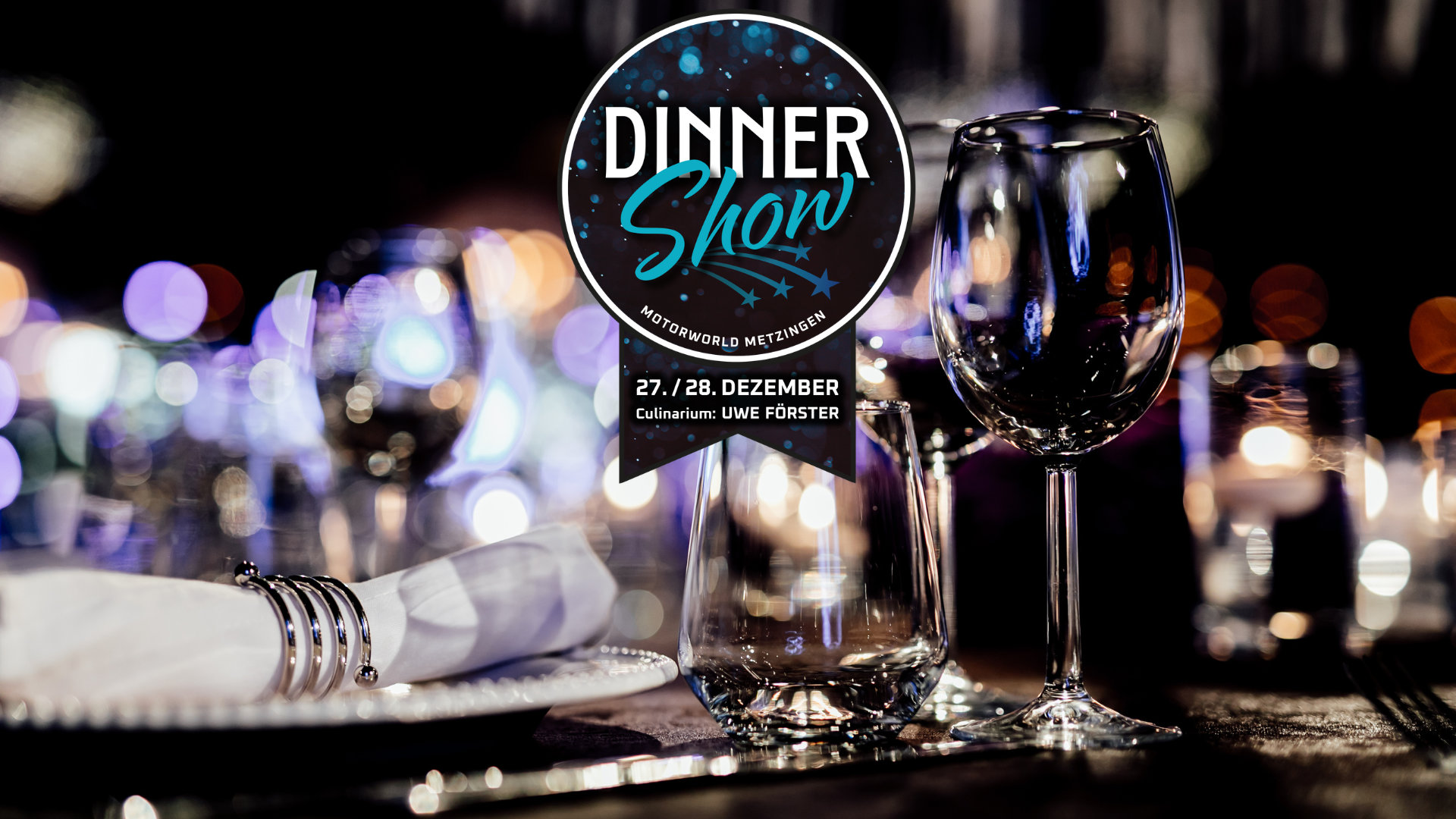 Elegantes gedeckter Tisch mit Wein- und Wasserglas, Besteck und Serviette vor unscharfem Hintergrund aus Lichtern und Textbanner mit Werbung für Dinner Show am 27. und 28. Dezember in Motorworld Metzingen mit Uwe Förster.