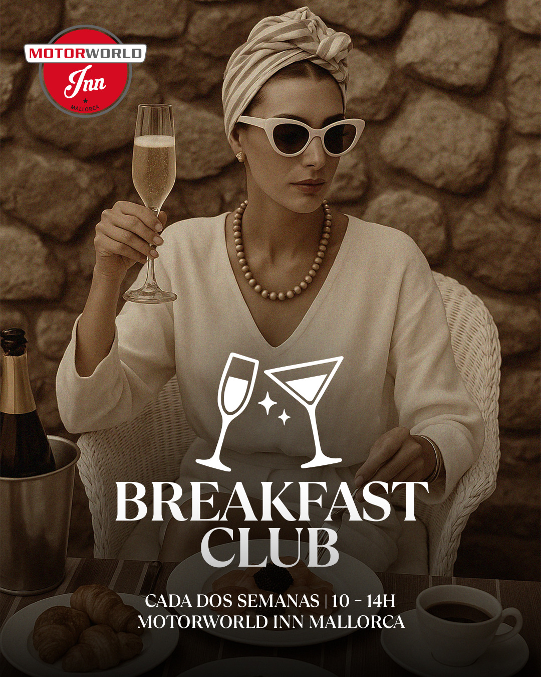 Woman with turban, pearl necklace and sunglasses holding a glass of champagne, sitting at a table with croissants, coffee and food in front of her, stone wall in the background, text with event information about breakfast at Motorworld Inn Mallorca