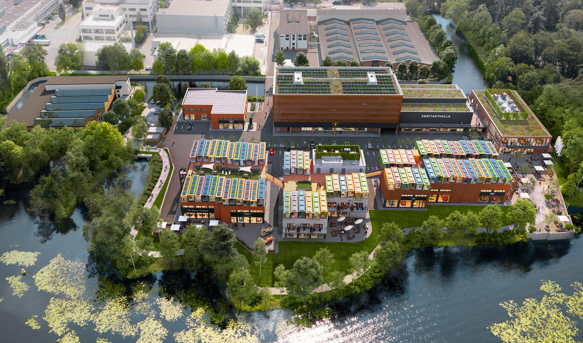 Aerial view of a modern building complex on the waterfront with green roofs and colorful solar panels, surrounded by trees and a river, with paths and park-like green spaces