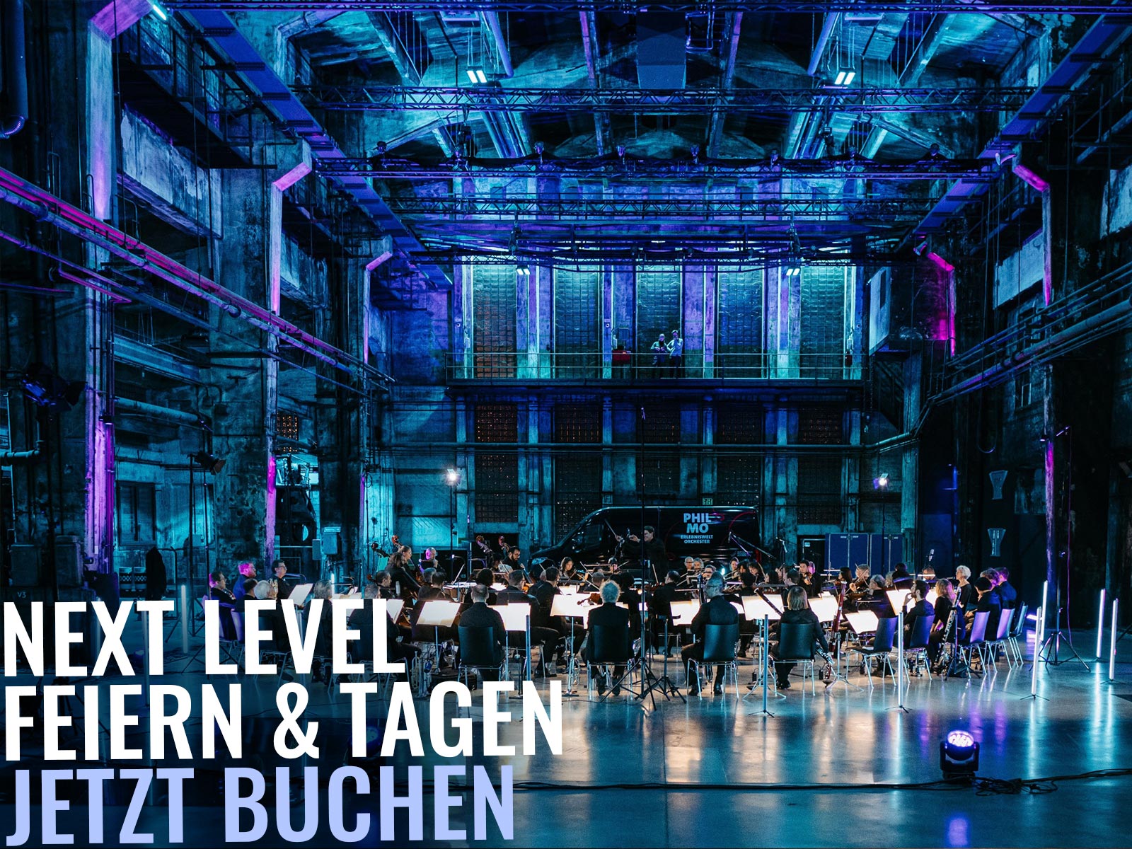 Orchester spielt in einer großräumigen, blau-violett beleuchteten Industriehalle; links großer Werbetext Next Level Jetzt buchen