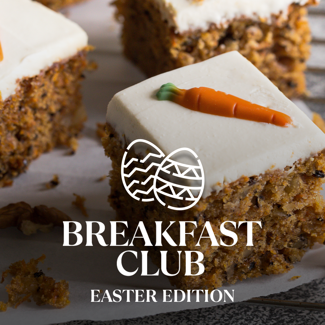 Stück Karottenkuchen mit weißer Glasur und Zuckermöhre, Text "Breakfast Club Easter Edition" überlagert.