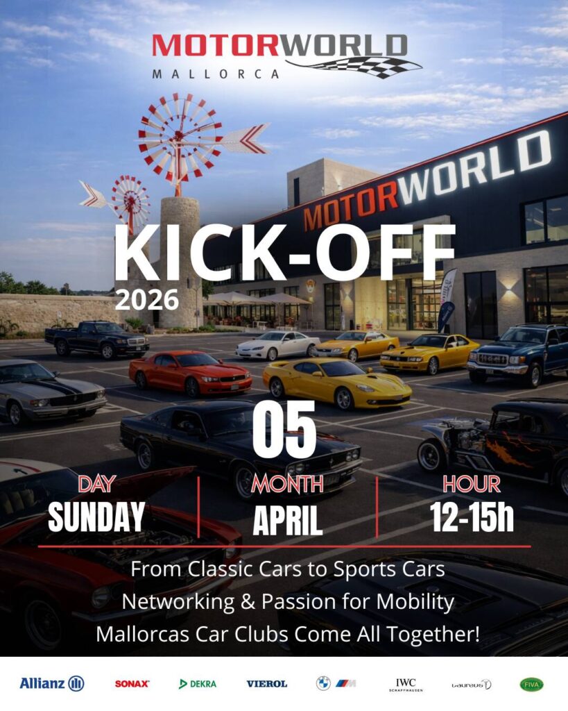 Parkplatz mit verschiedenen klassischen und Sportwagen vor dem Motorworld Mallorca Gebäude und Veranstaltungsschriftzug "Kick-Off 05 April 12-15h".