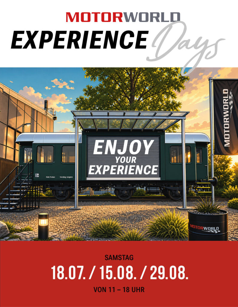 Werbewand mit Schriftzug "Enjoy Your Experience" vor einem grünen Waggon, Bäumen und Motorworld-Logo über einem roten Datumsfeld.