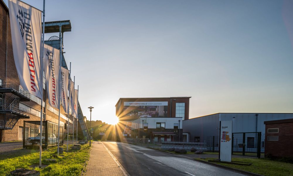 Sunset at an industrial complex with Motorworld flags and an empty street